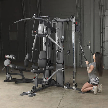 Woman using Body-Solid home gym with cable pulleys for strength training.