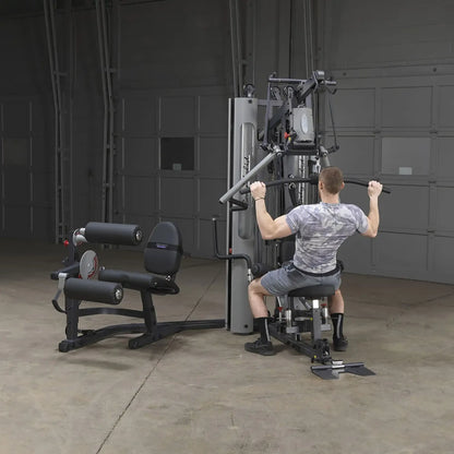 Man using Body-Solid home gym equipment for strength training in a garage.