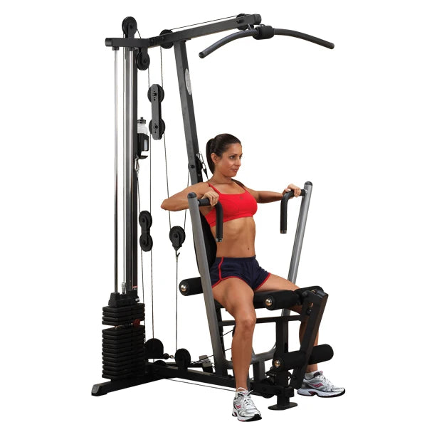 Woman exercising on a home gym machine in red sportswear.
