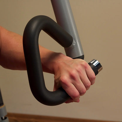 Hand gripping black ergonomic exercise machine handle.