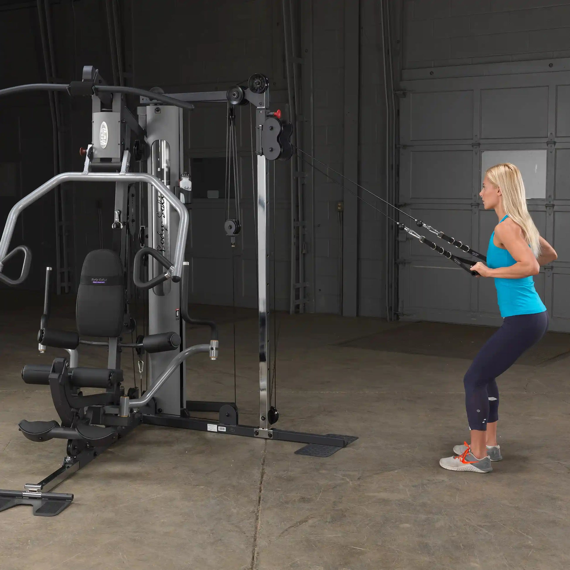 Woman using a Bowflex home gym with cables for strength training.