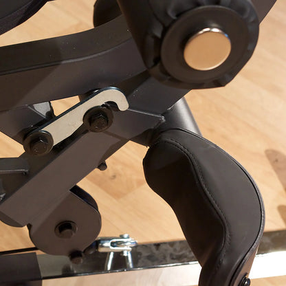 Adjustable black leather leg curl attachment on a gym machine.
