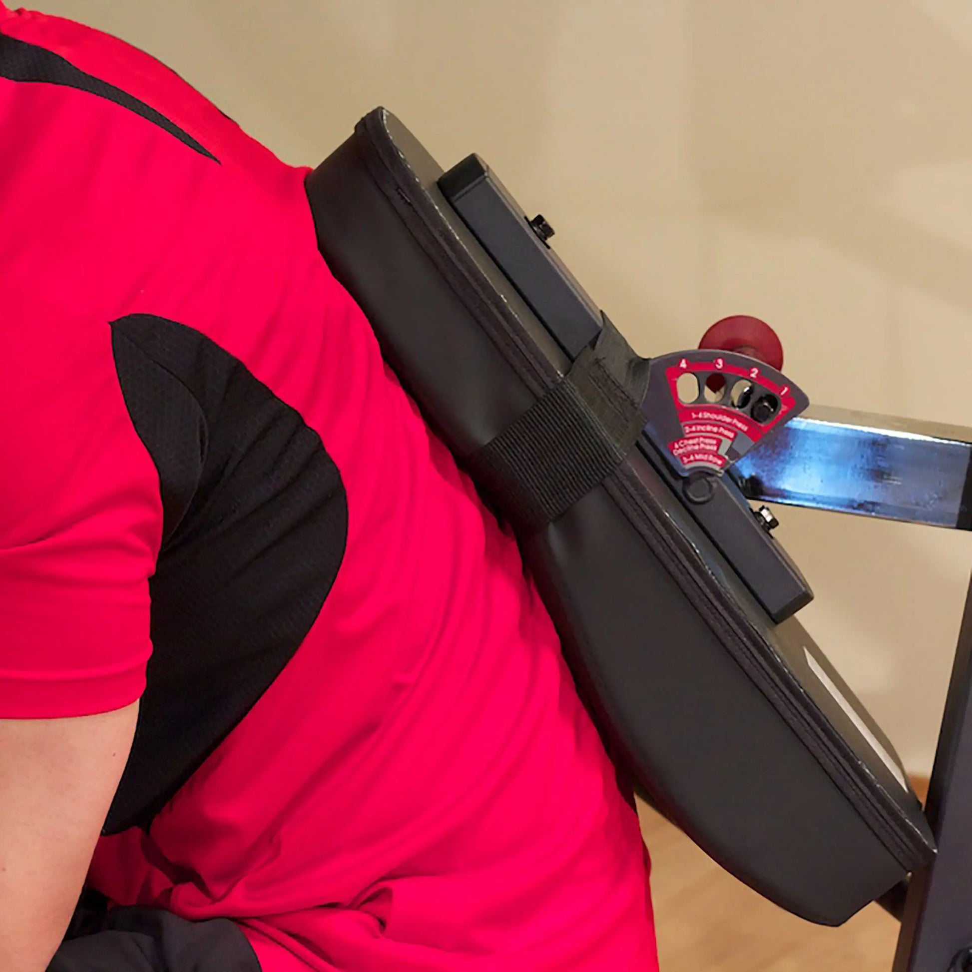 Seated row machine with red shirted user and adjustable back support.