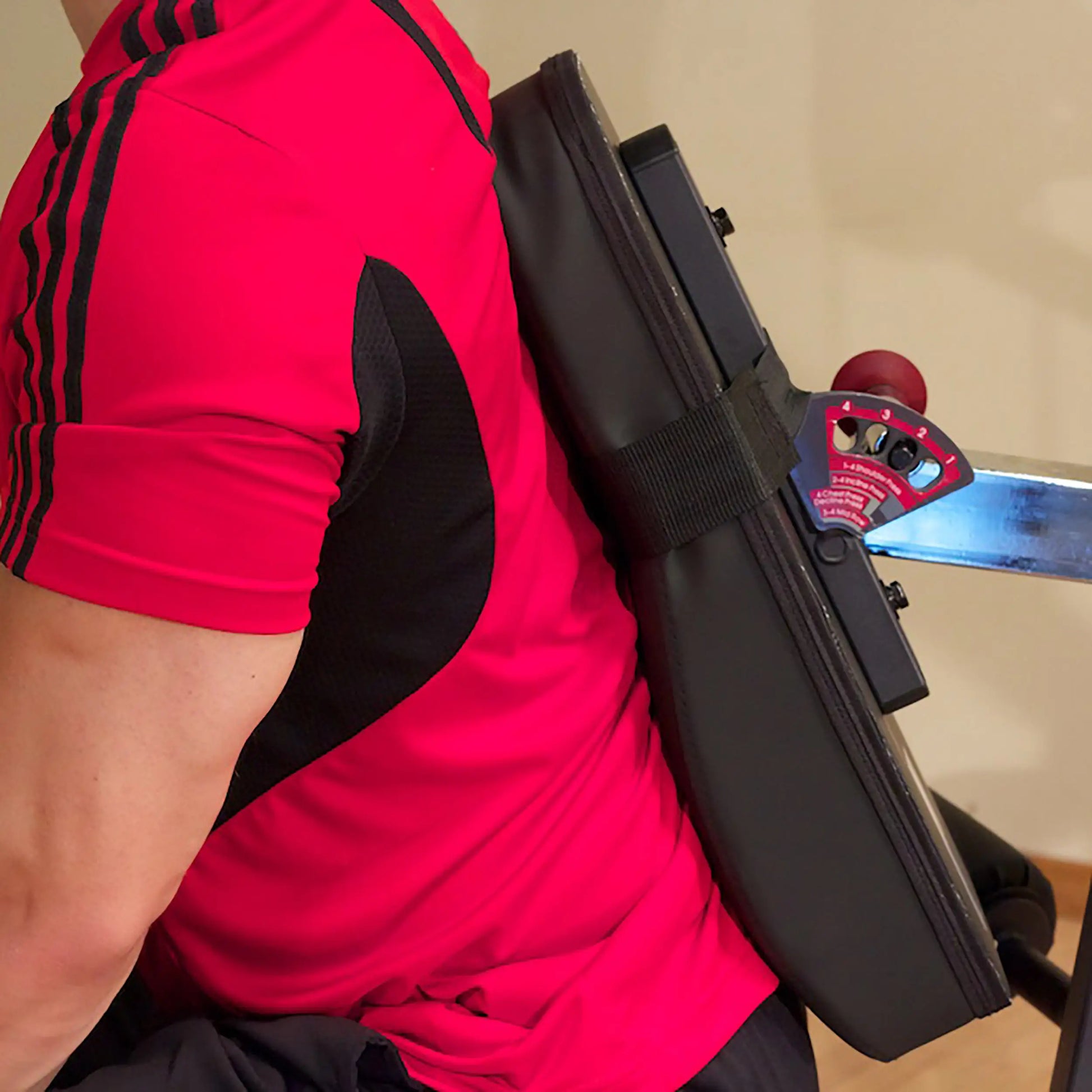 Man wearing red shirt using a black posture correction device.
