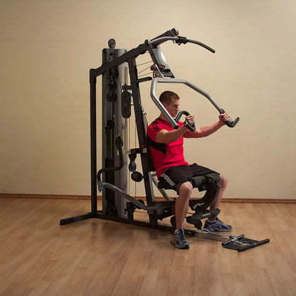 Man using a home gym machine for strength training in a red shirt.