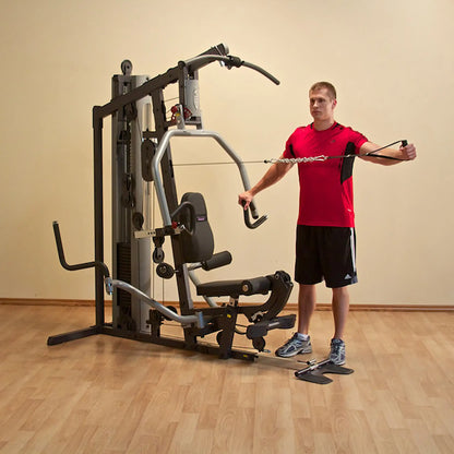 Man using multi-gym machine in red shirt for strength training.