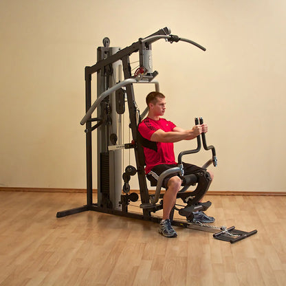 Man using a multifunctional home gym machine in a red shirt.