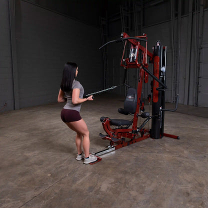 Woman using maroon Body-Solid home gym equipment for strength training.