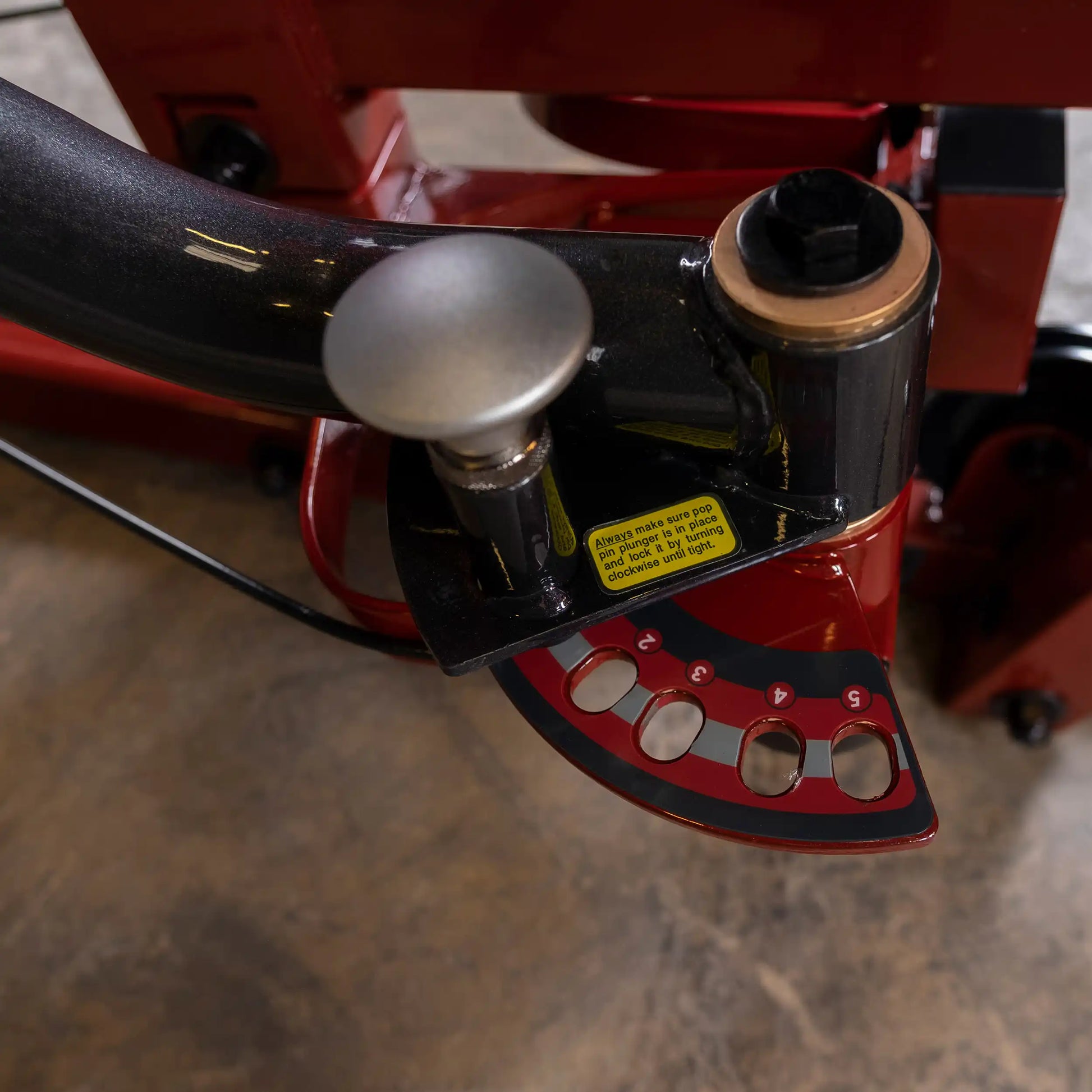 Red hydraulic tubing bender with angle adjustment dial and black handle for precision metalwork.