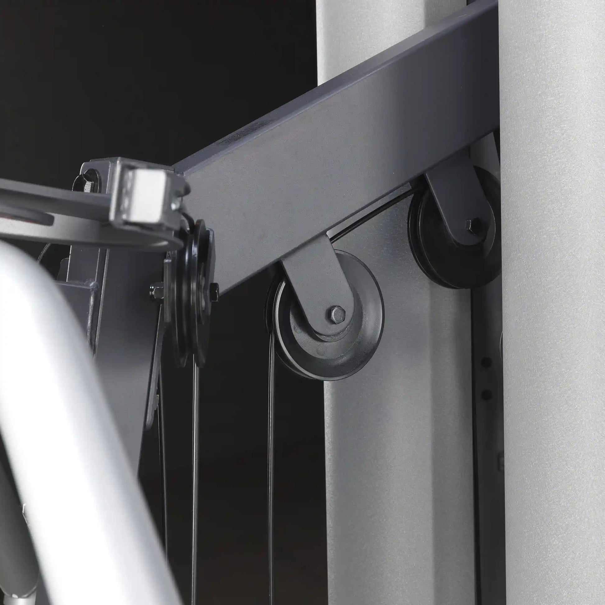 Gym equipment pulley system with black cables and metal frame.