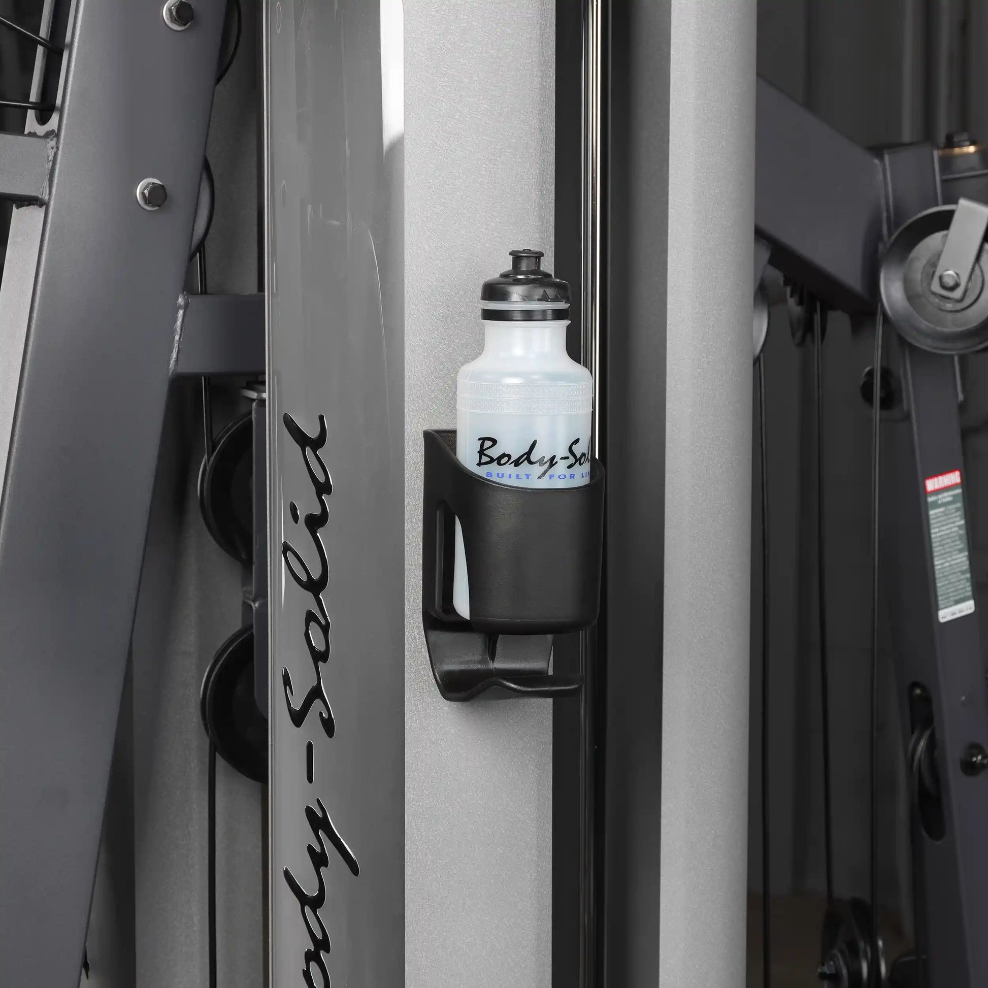 Body-Solid gym machine with a white water bottle in a black holder.