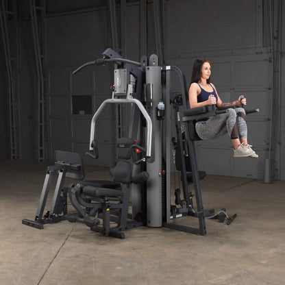 Woman using BodyCraft XPress Pro gym machine for leg raises.