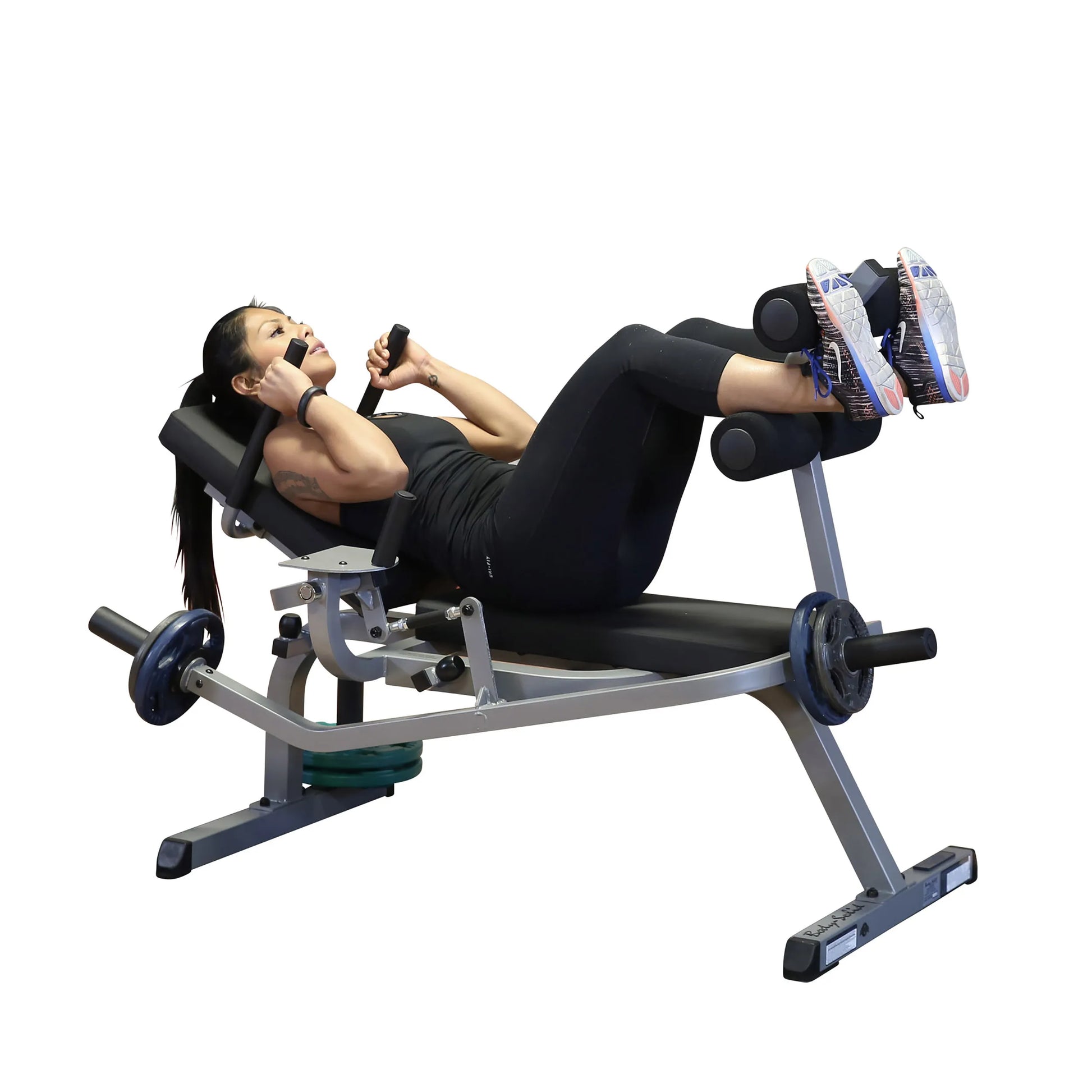 Woman exercising on a leg press machine in black workout attire.