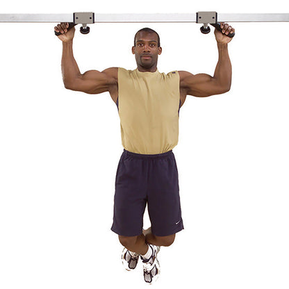 Man doing pull-ups on a metal bar in a beige tank top and navy shorts.