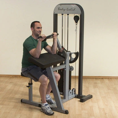 Man using Body-Solid bicep curl machine in a gym.