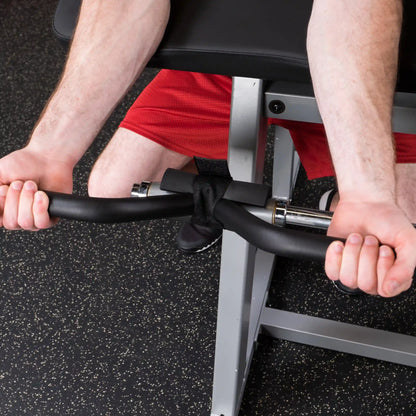 Man using a black EZ curl bar with wrist straps for bicep curls on a gym bench.