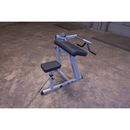 Preacher curl bench with adjustable seat and arm pad for bicep workouts in a gym setting.