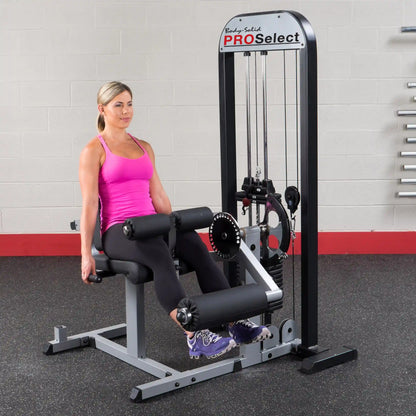 Woman using Body-Solid PRO Select leg extension machine in gym.