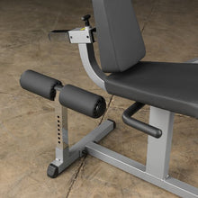 Adjustable weight bench with black padding and leg support for home gym workouts.