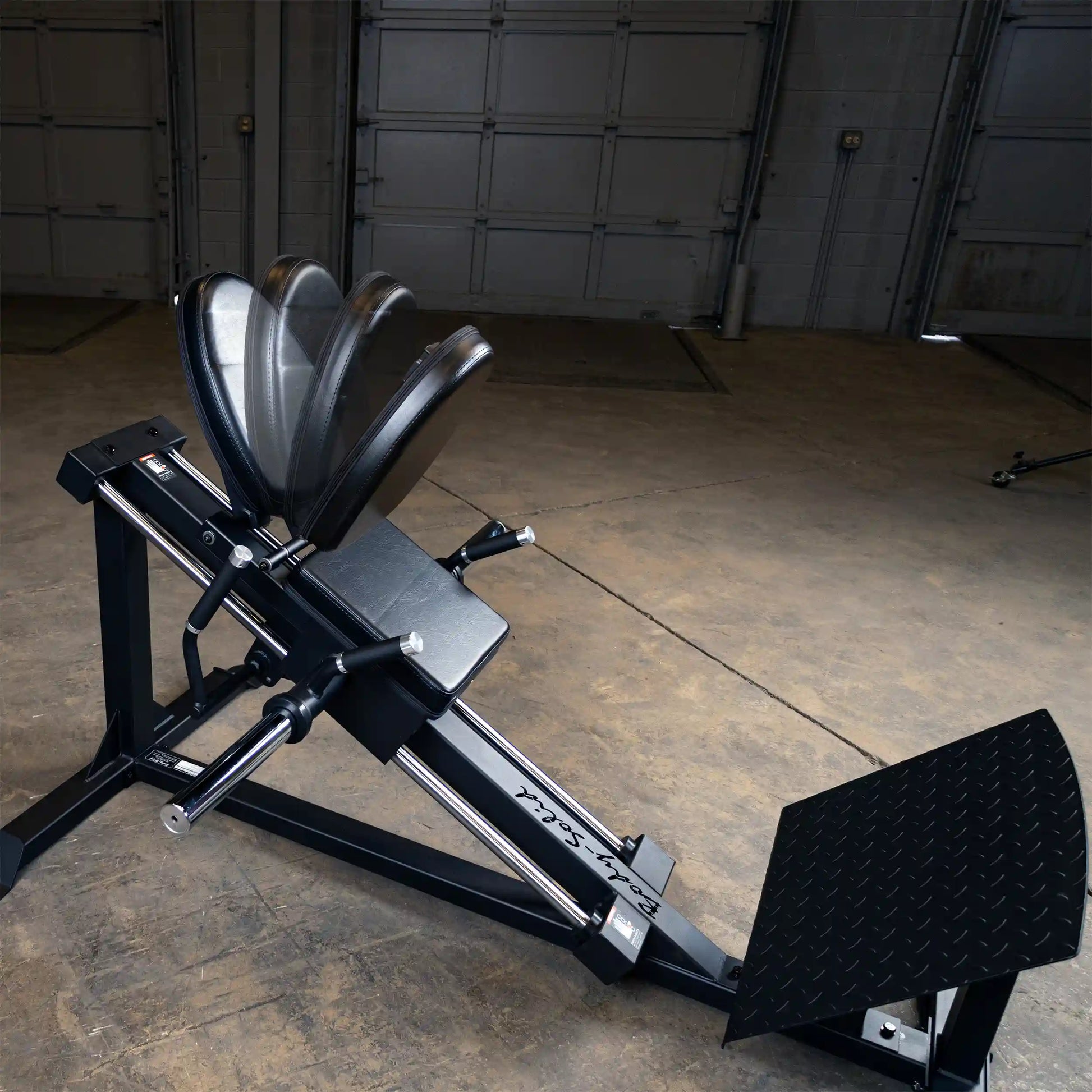 Rogue ISO Leg Press in black with adjustable seat and footplate in a warehouse gym.