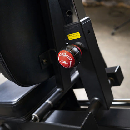 Adjustable gym equipment knob with red To Adjust Loosen label, featuring black metal frame.