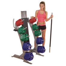 Woman with Body-Solid weight set, colorful plates on rack, holding barbell.