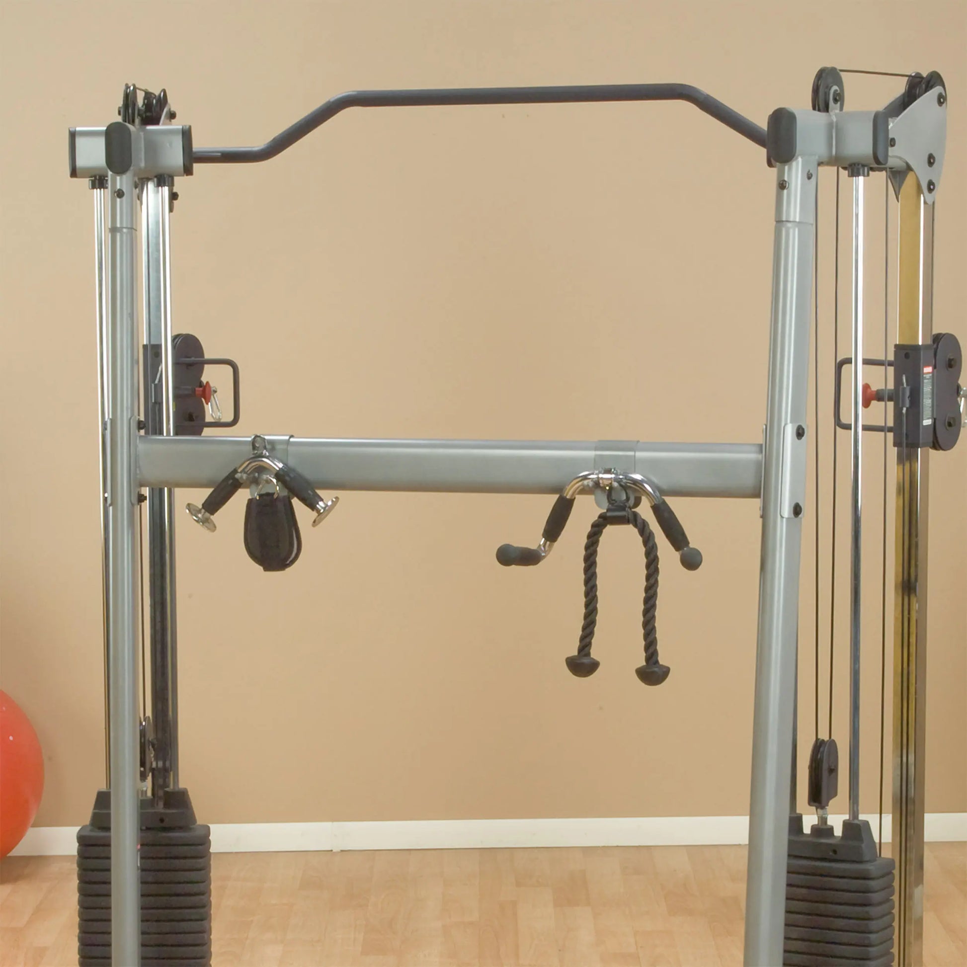 Cable crossover machine with dual pulley system and rope attachment for upper body workouts.
