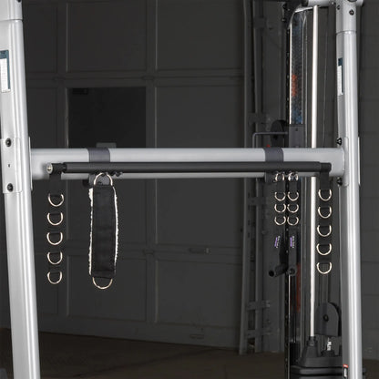 Dual cable cross machine with multiple D-rings and padded strap for versatile workouts.