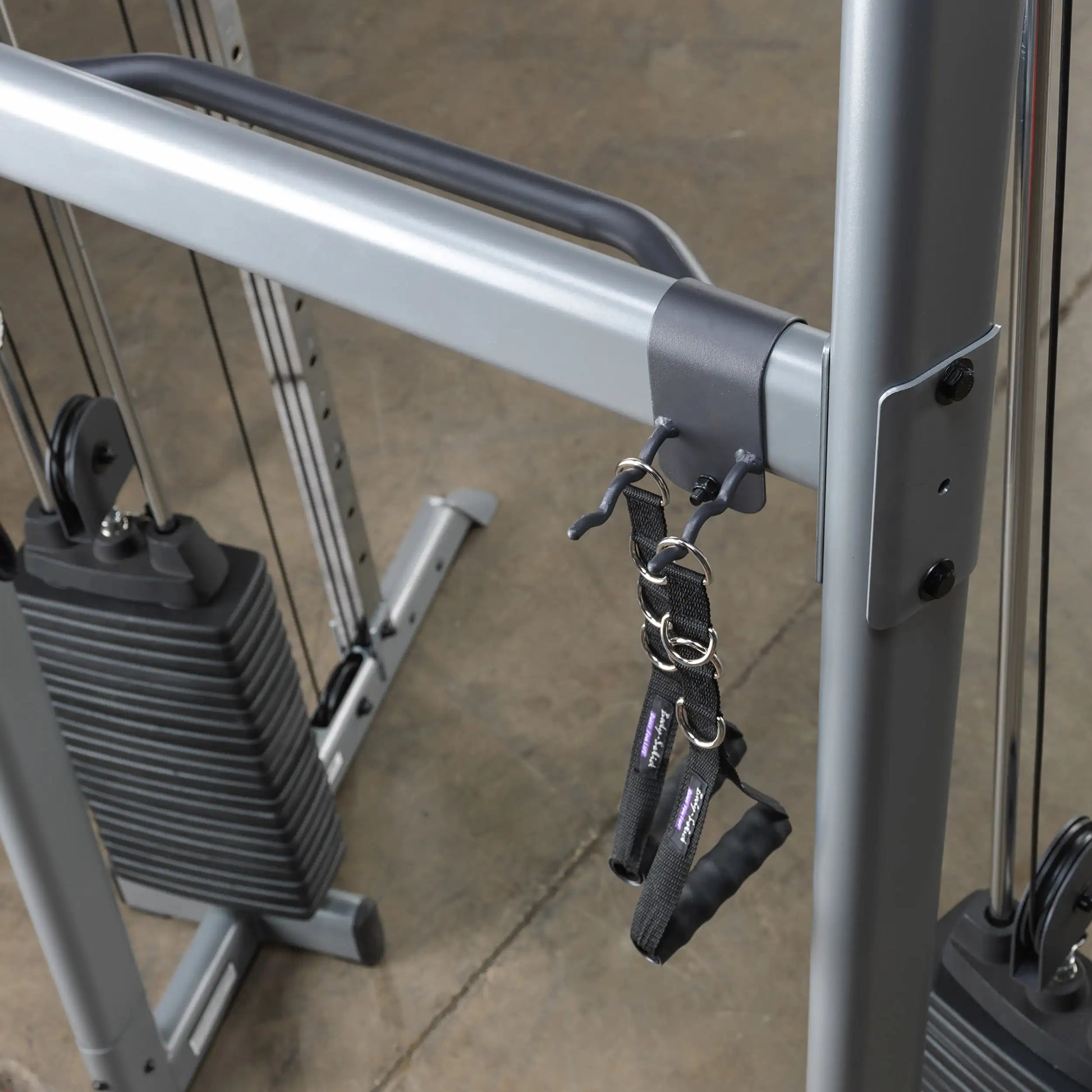 Body-Solid functional trainer with adjustable pulleys and black handles for versatile gym workouts.