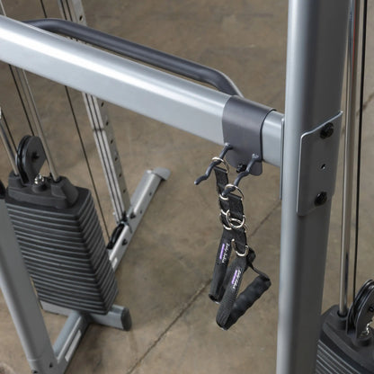 Body-Solid functional trainer with adjustable pulleys and black handles for versatile gym workouts.