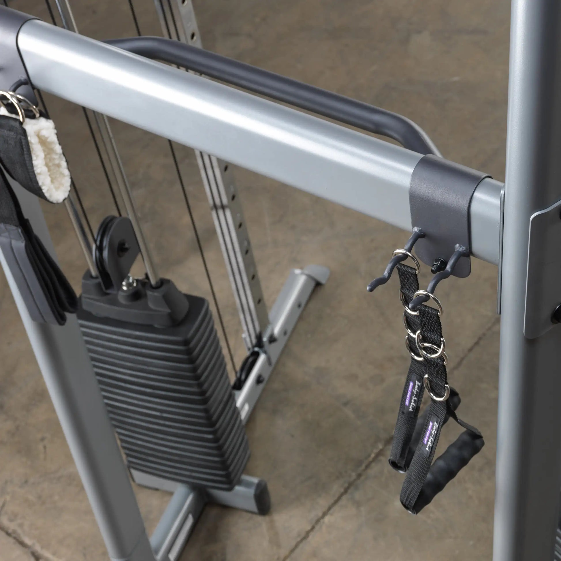 Cable machine with adjustable weight stack and black nylon handles for strength training.