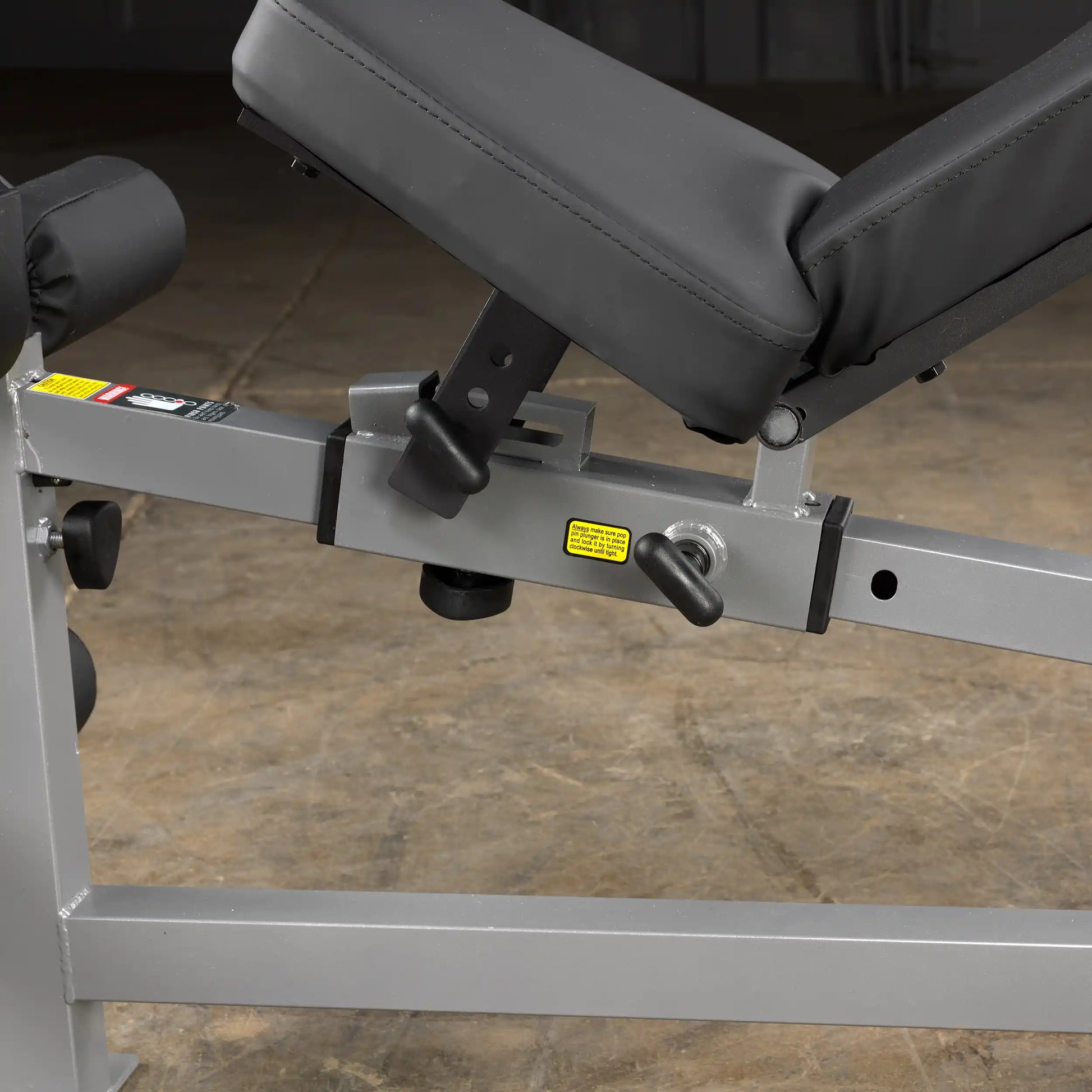 Adjustable weight bench with black cushion and silver frame, featuring a secure locking mechanism.