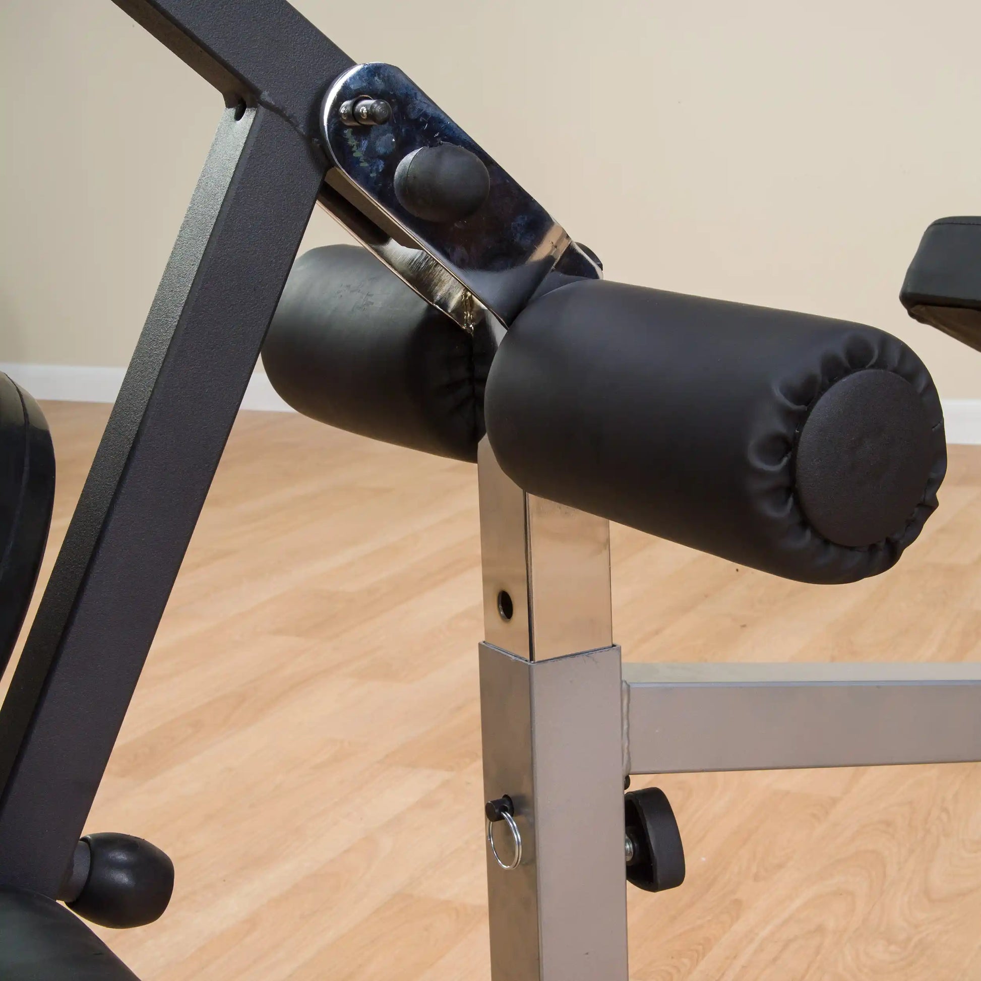 Adjustable weight bench with black padded rollers and metallic frame, perfect for home gym setups.