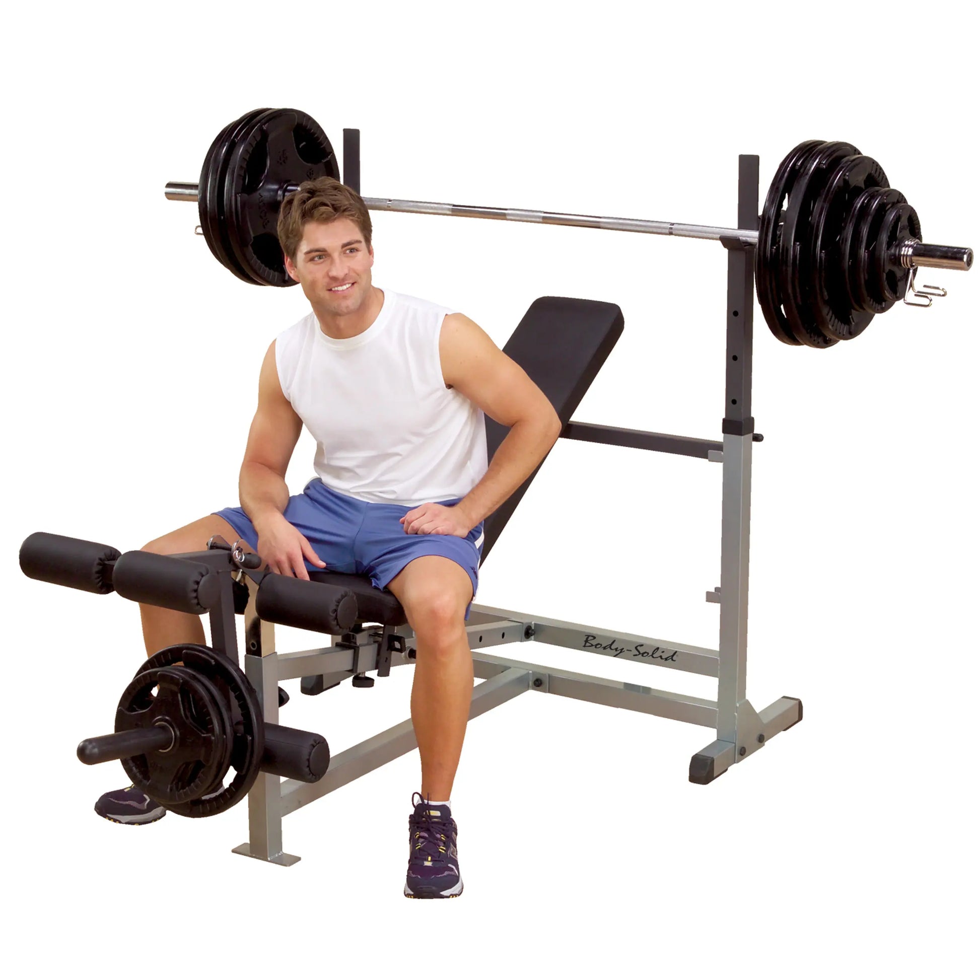 Man sitting on Body-Solid weight bench with barbell, wearing white tank and blue shorts.