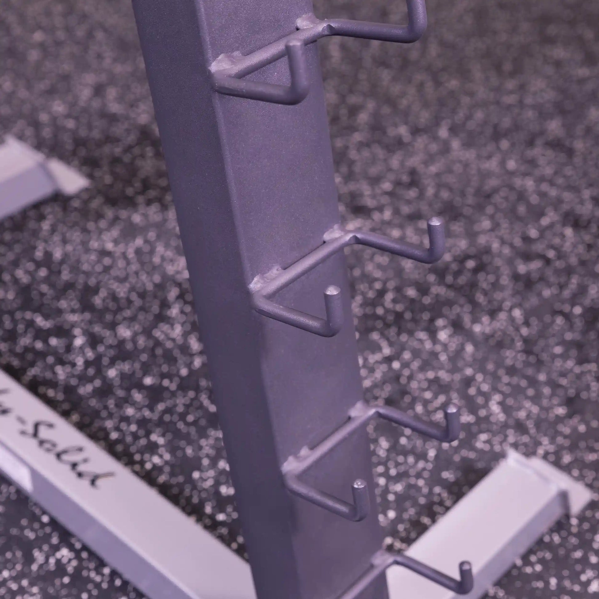 Body-Solid gray barbell rack with multiple hooks on speckled gym floor.