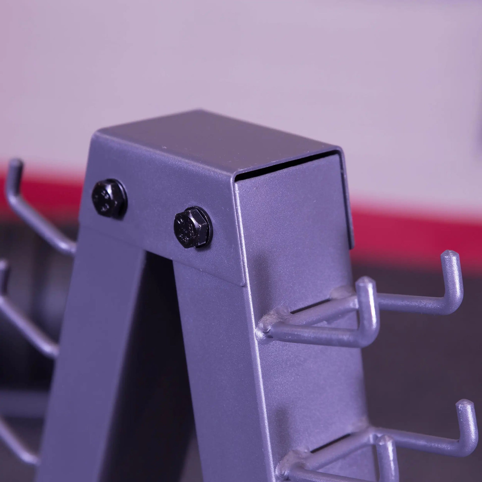 Steel dumbbell rack corner with multiple storage hooks, featuring a durable matte gray finish.
