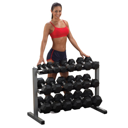 Woman in red top with a dumbbell rack, featuring hexagonal weights, ideal for home gym setups.