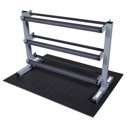Steel dumbbell rack with three tiers on a rubber mat for gym organization.