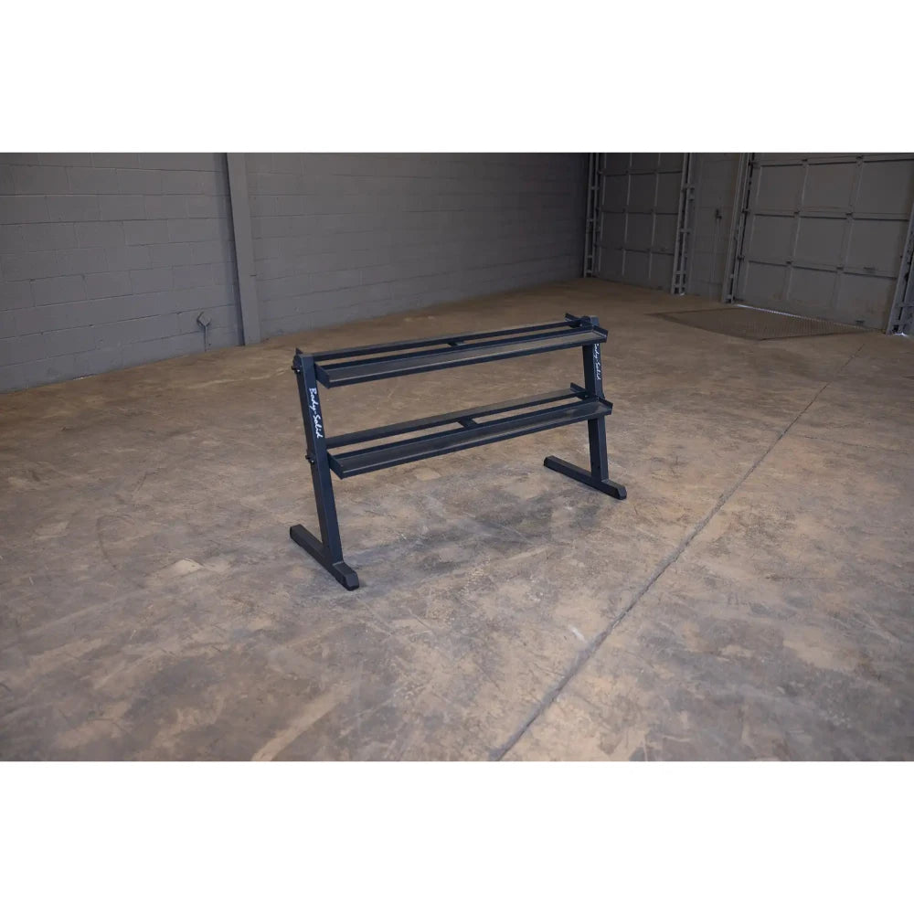 Black steel dumbbell rack in an empty gym space.