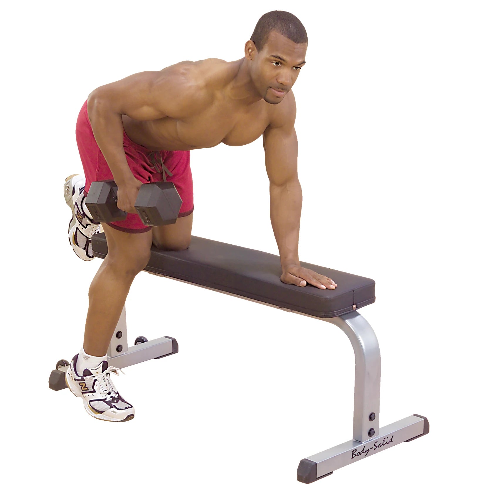 Man performing dumbbell row on Body-Solid bench, wearing red shorts.