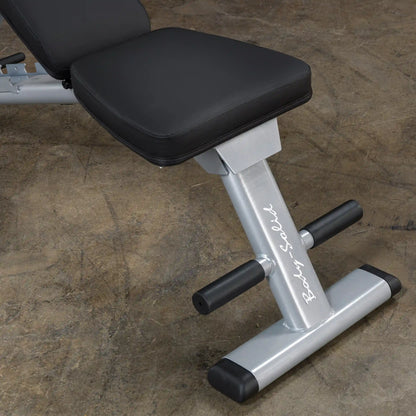 Body-Solid weight bench with black cushioned seat on a concrete floor.
