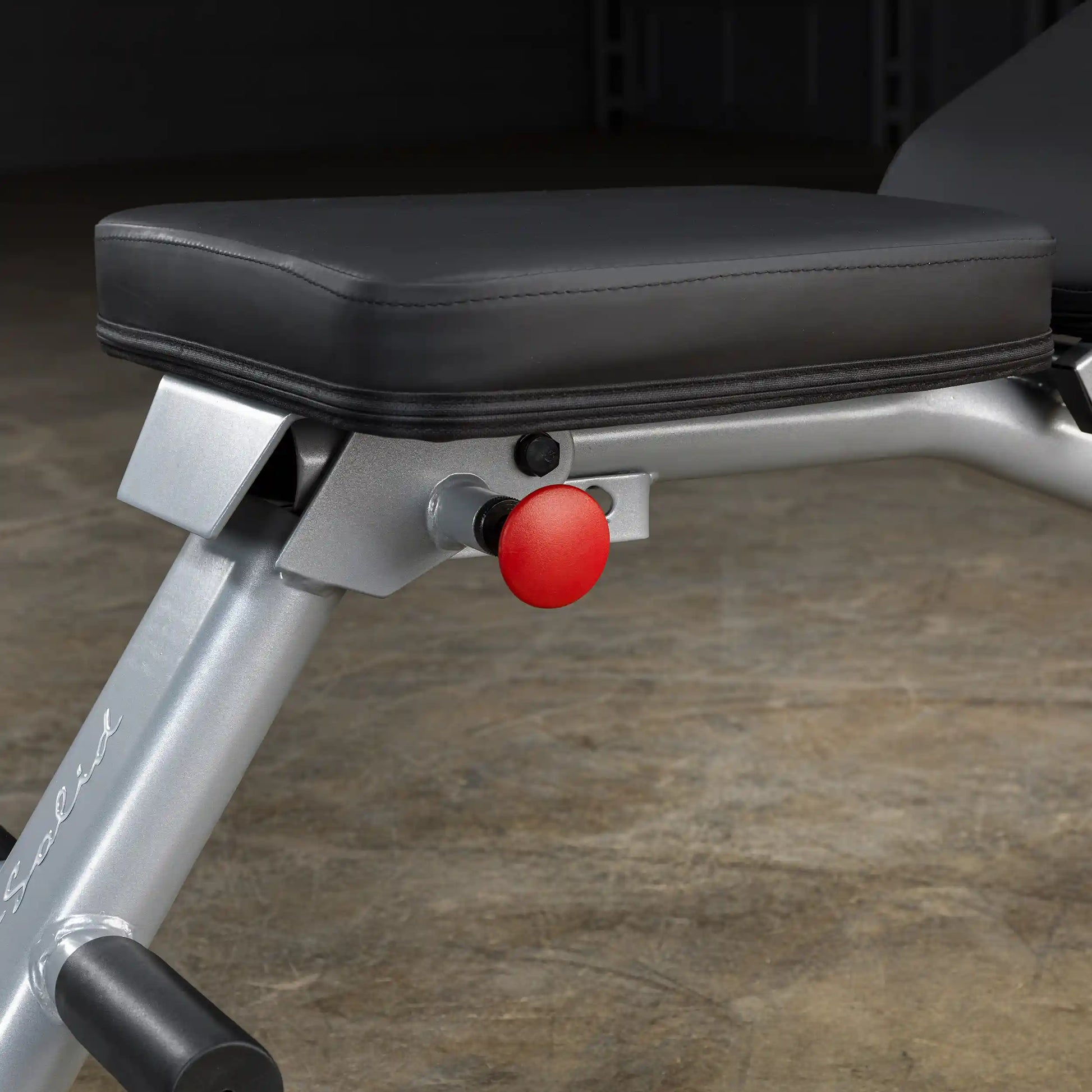 Adjustable weight bench with black cushion and red adjustment knob.