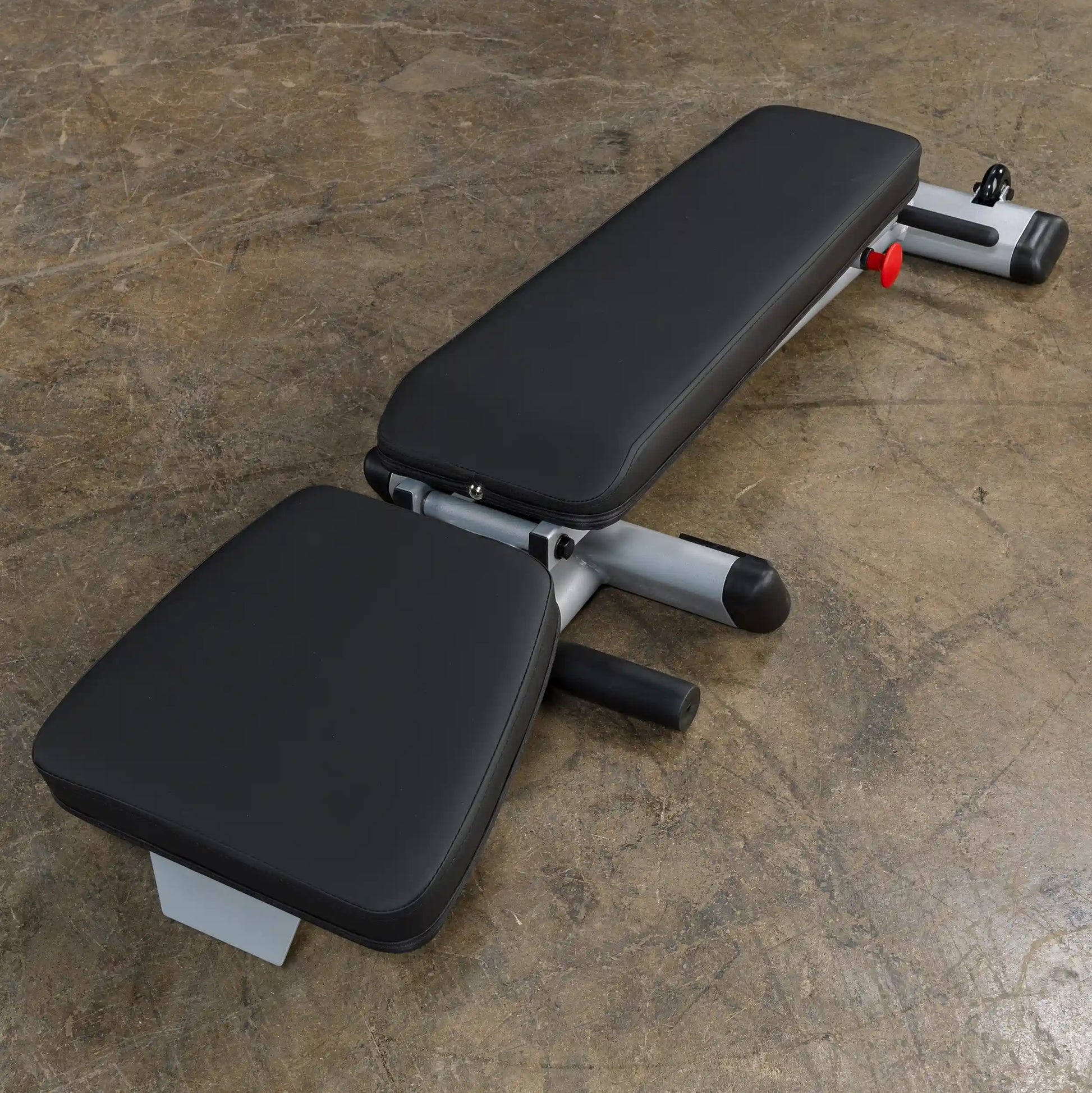 Adjustable black flat weight bench on concrete floor.