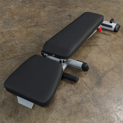 Adjustable black flat weight bench on concrete floor.