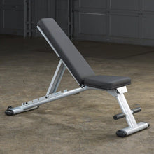 Adjustable weight bench with black padding and silver frame in a gym setting.