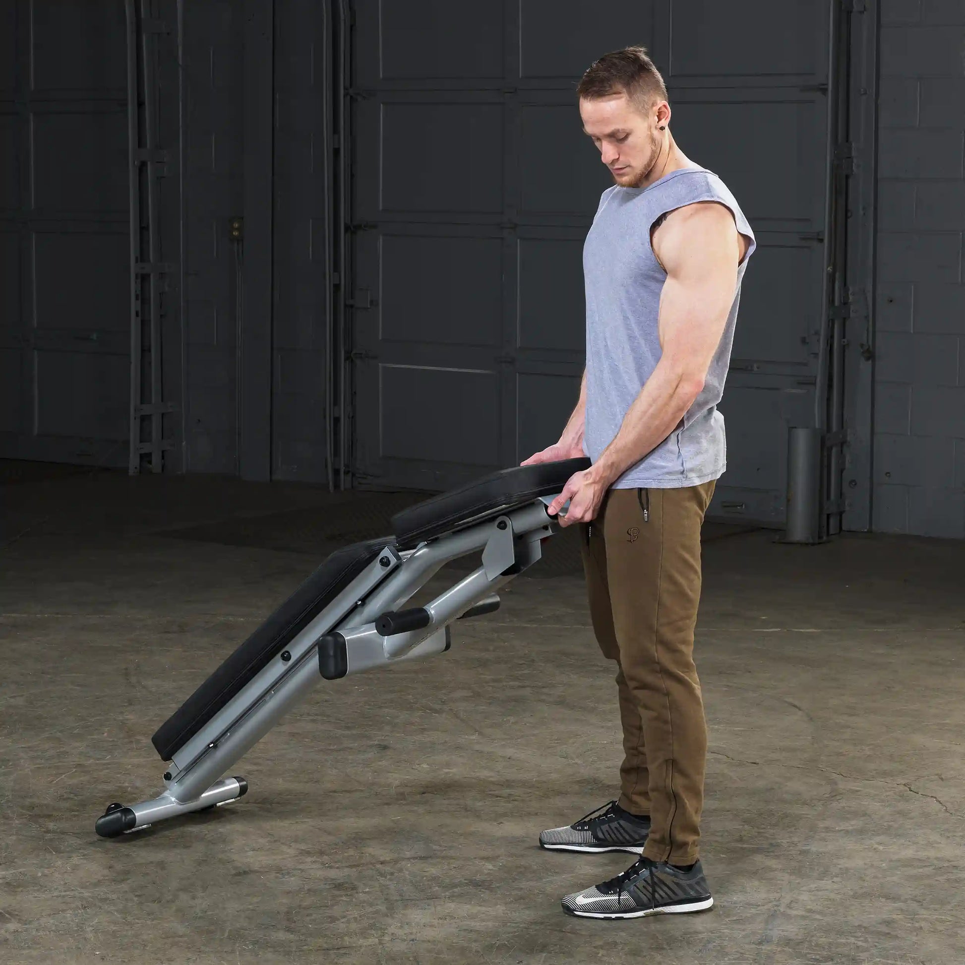Man adjusting adjustable weight bench in a gym.
