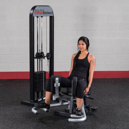 Woman using Body-Solid PRO Select inner thigh machine in gym.