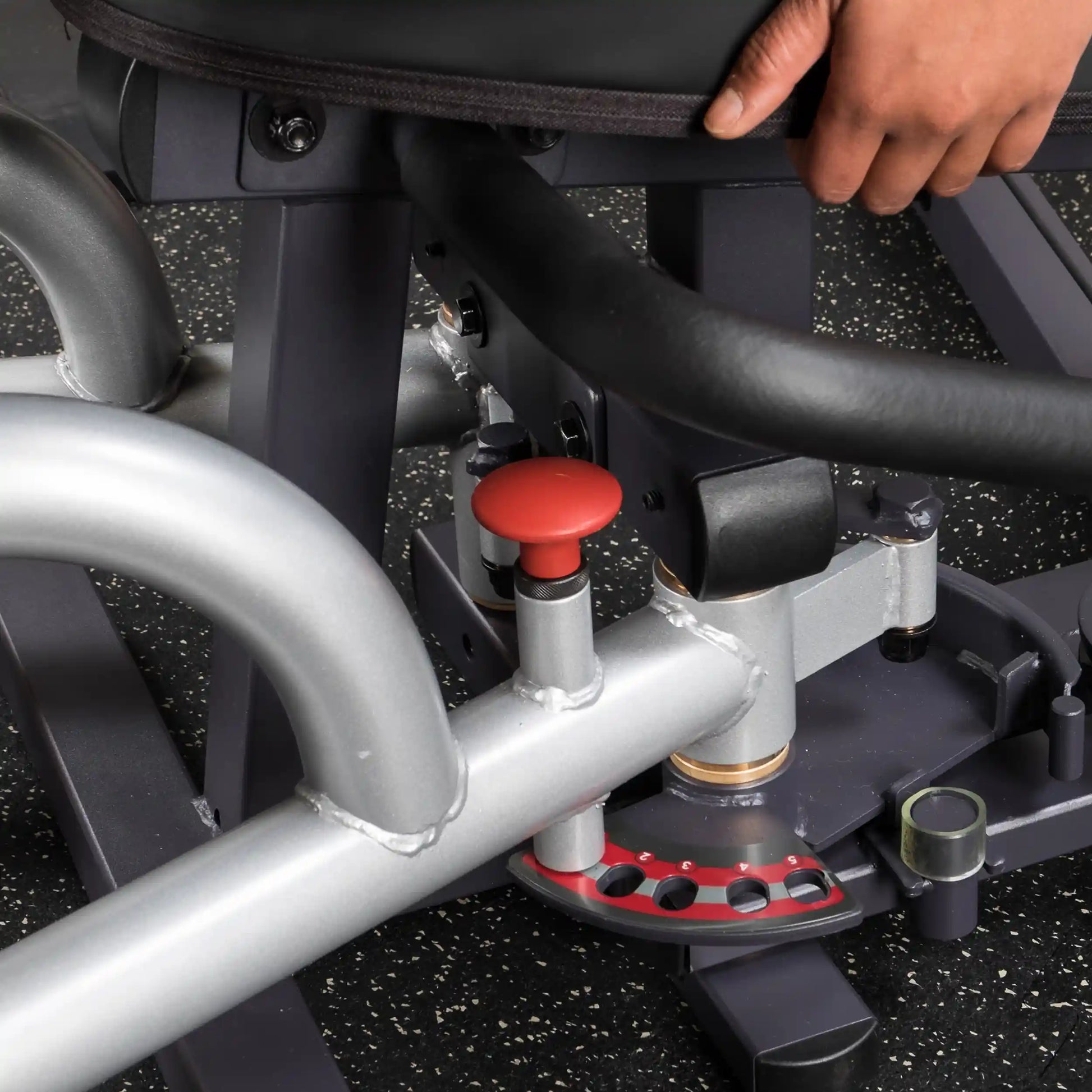 Gym equipment with adjustable setting and red knob for precise workout customization.