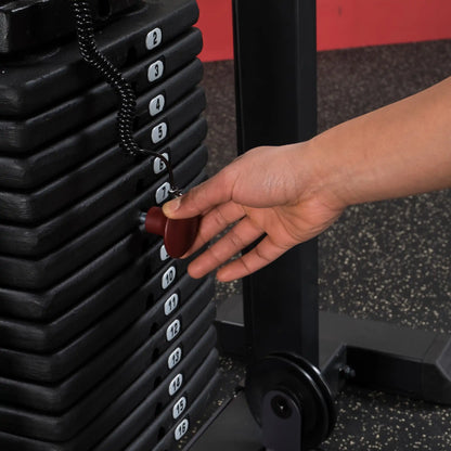 Hand adjusting weight selector pin on black gym machine stack for customized workout.