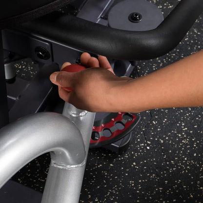Adjusting red knob on gym equipment for weight settings.